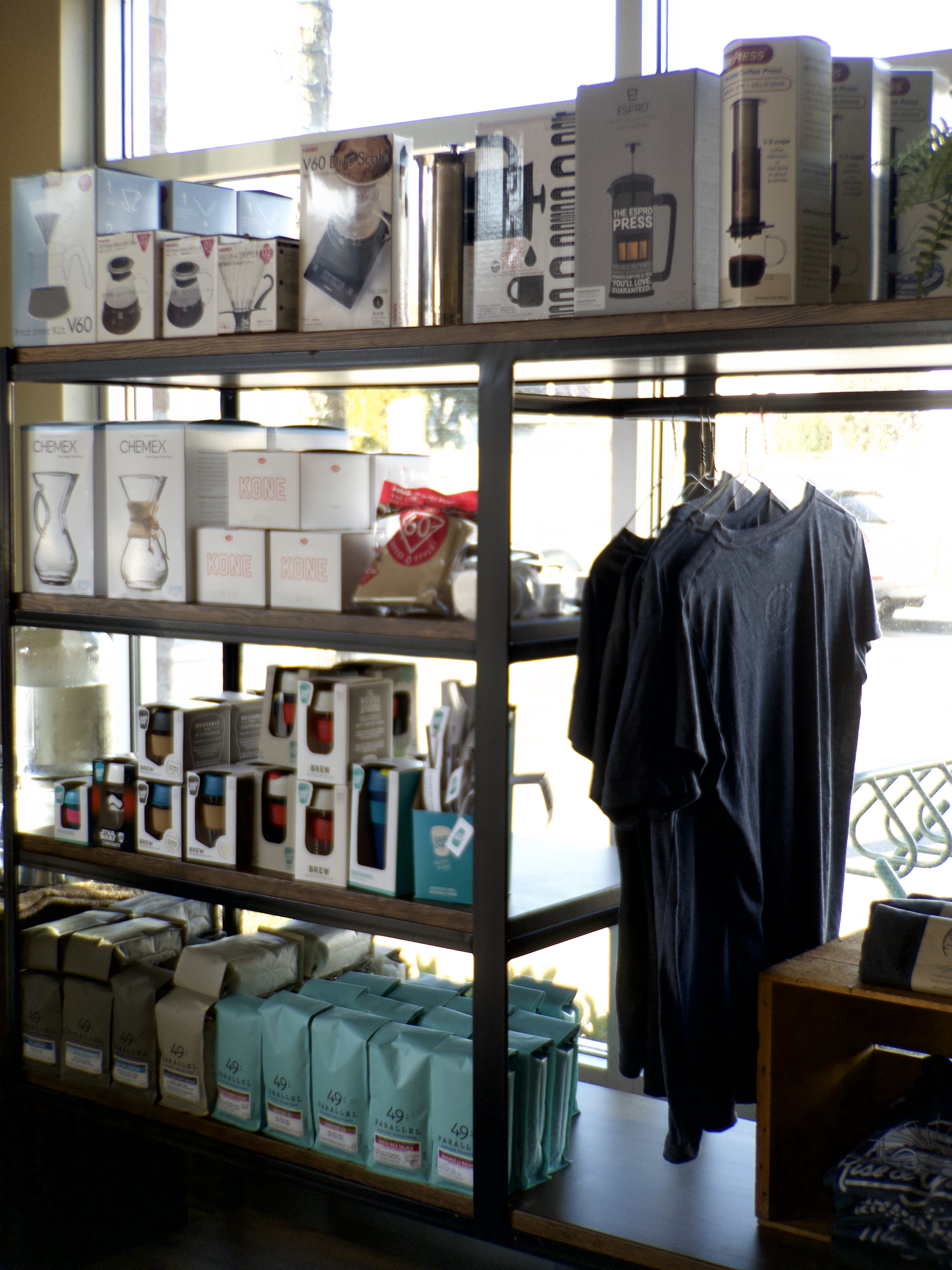 A collection of retail coffee items on a display shelf in a coffee shop